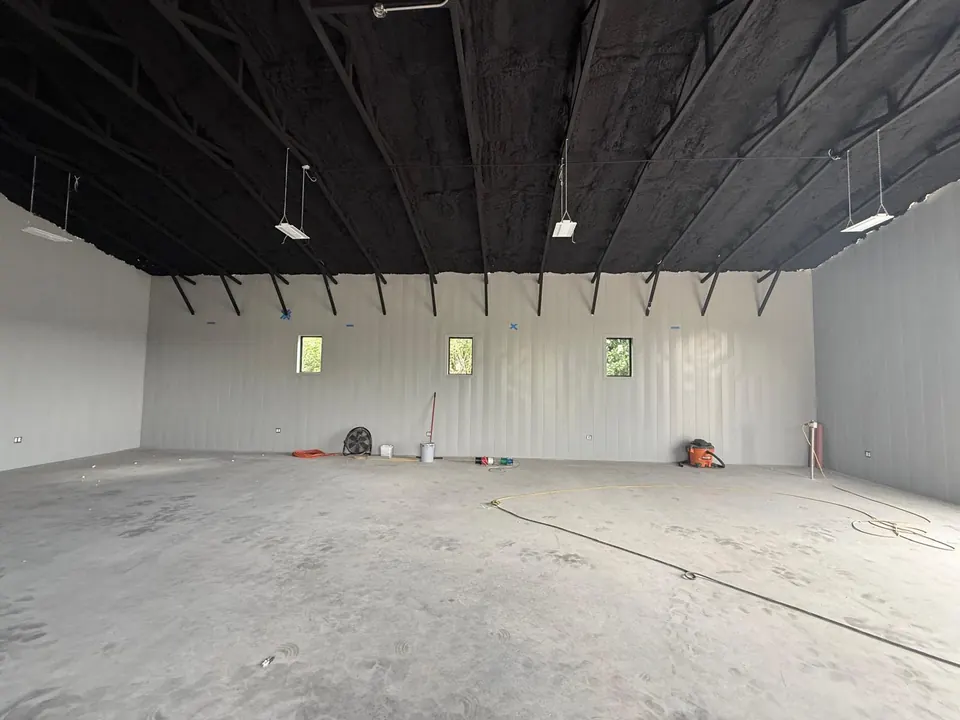 Metal panel walls below dark roof structure